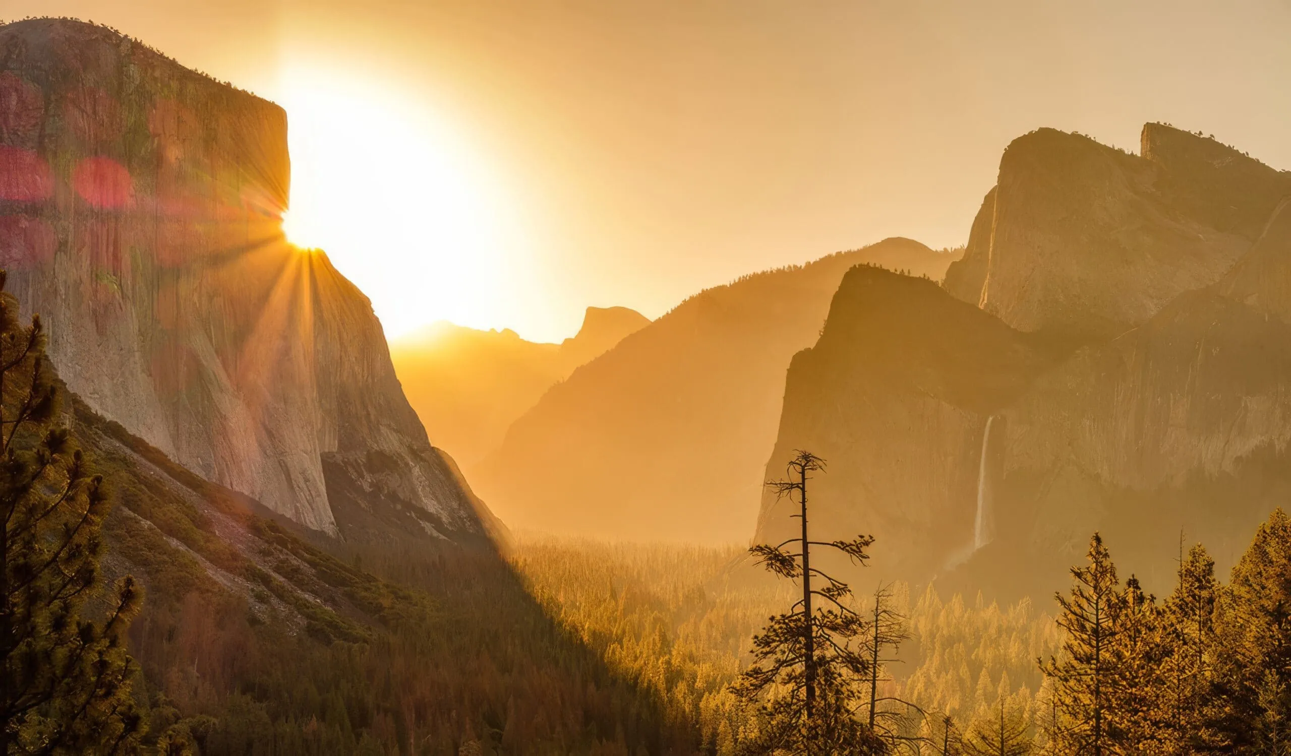 Tunnel View Yosemite National Park at sunrise with golden light illuminating Half Dome and El Capitan