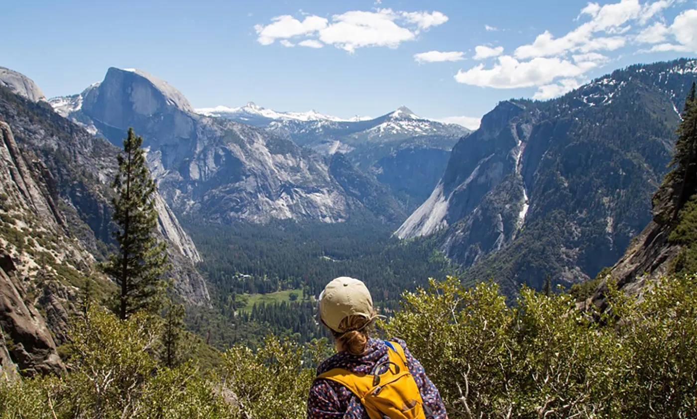 Hiker overlooking Yosemite Valley with Half Dome in background