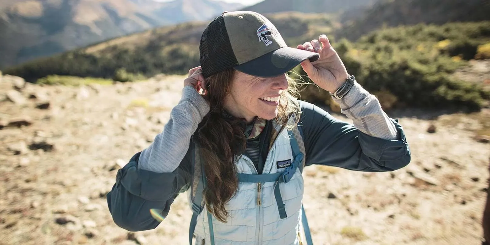 Hiker demonstrating proper layering technique on mountain trail