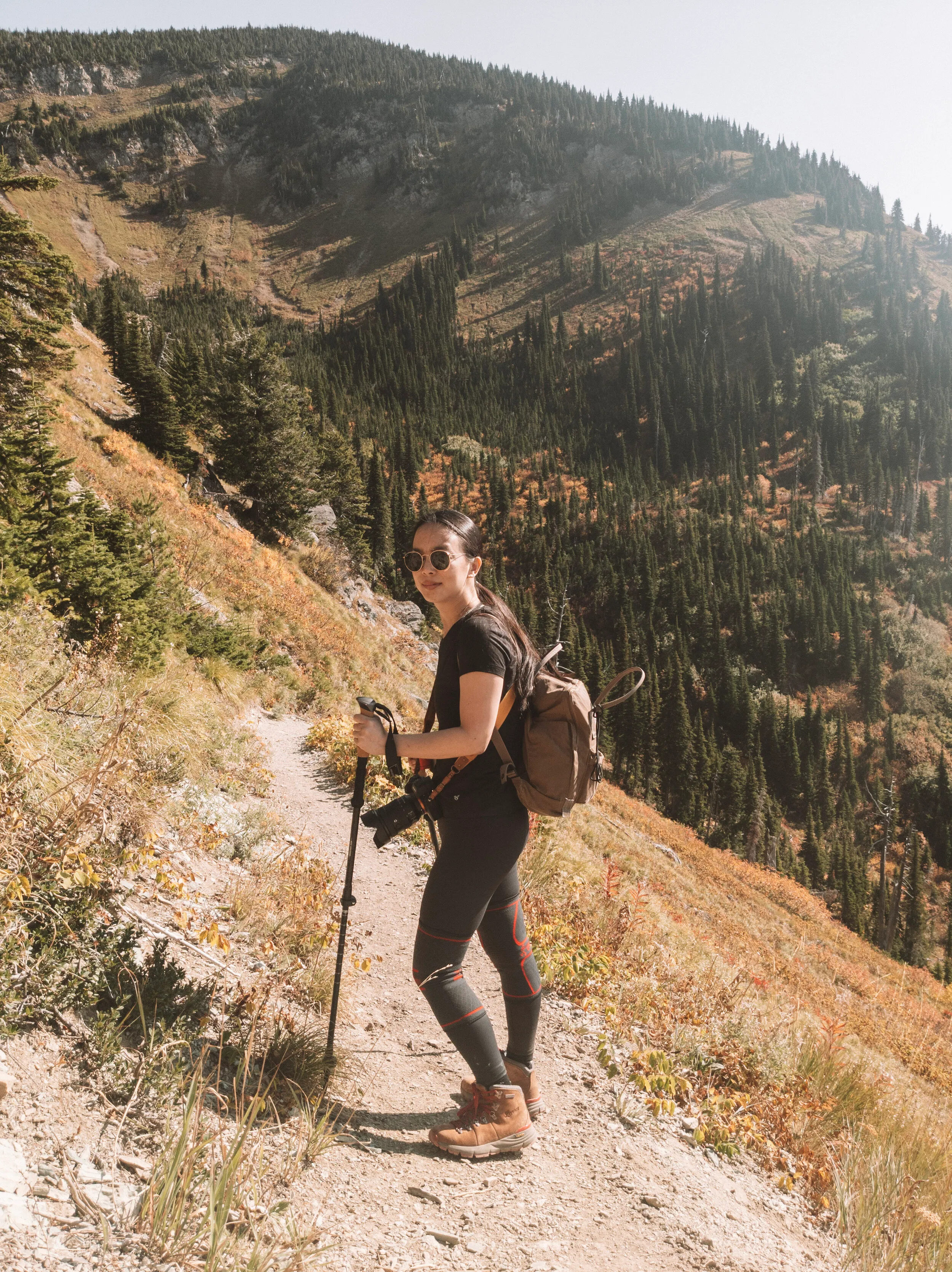 Female hiker wearing proper hiking pants and layers on autumn trail