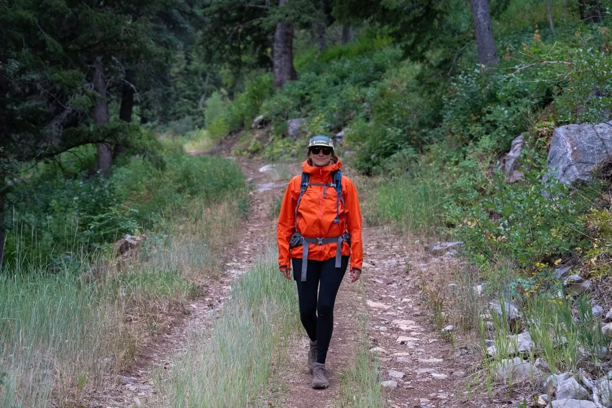 Hiker wearing rain jacket in stormy mountain conditions