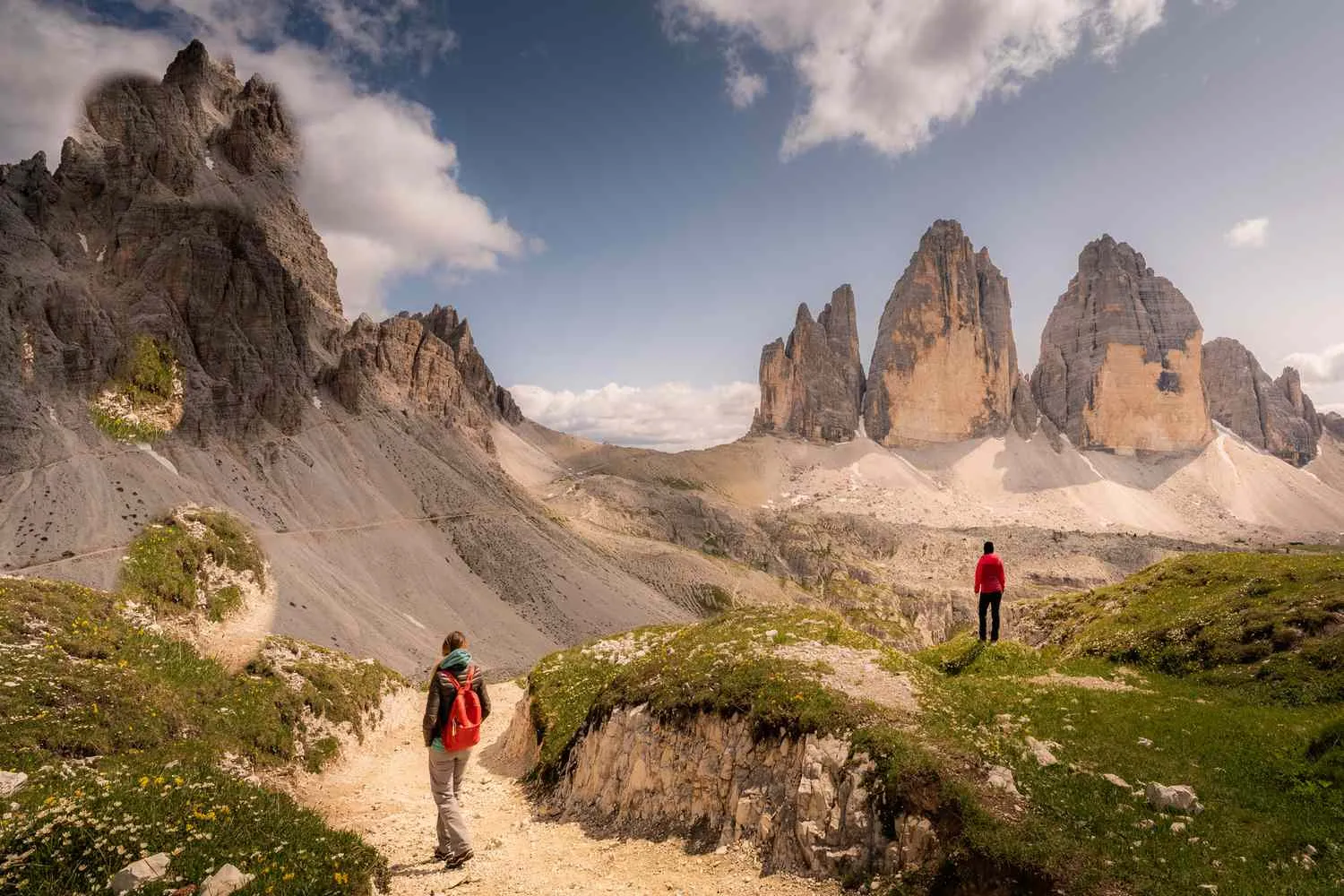 Dramatic limestone peaks and spires of the Dolomites with hiking trails winding through alpine meadows