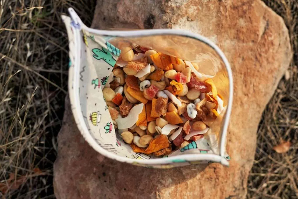 Homemade trail mix with nuts, dried fruits, and seeds displayed in a wooden bowl, perfect for safe trail snacking