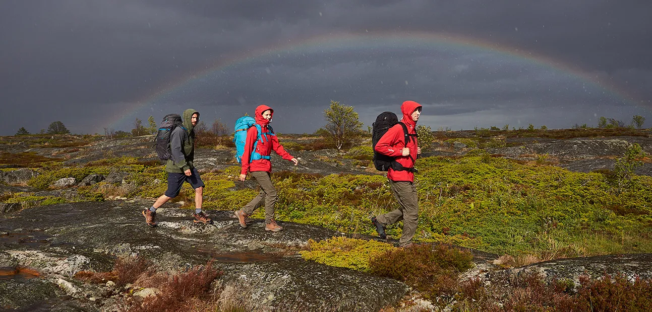 Hiker reading weather patterns and cloud formations in mountain environment