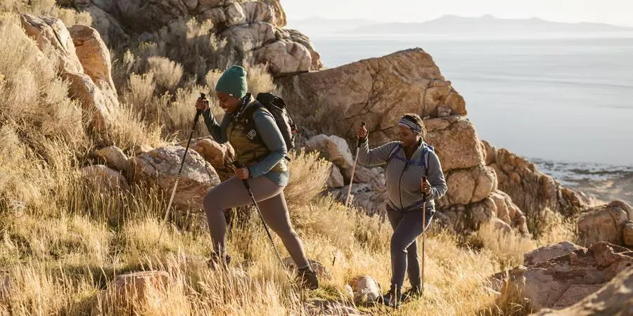 Beginner hikers on a scenic mountain trail with backpacks and hiking gear