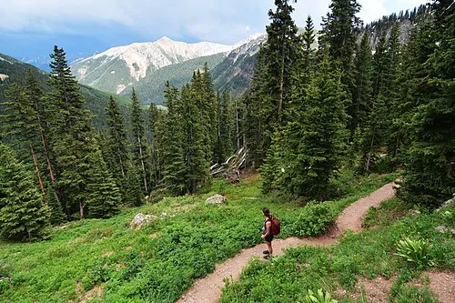 Hikers walking on mountain trail in San Juan National Forest Colorado showing what is hiking