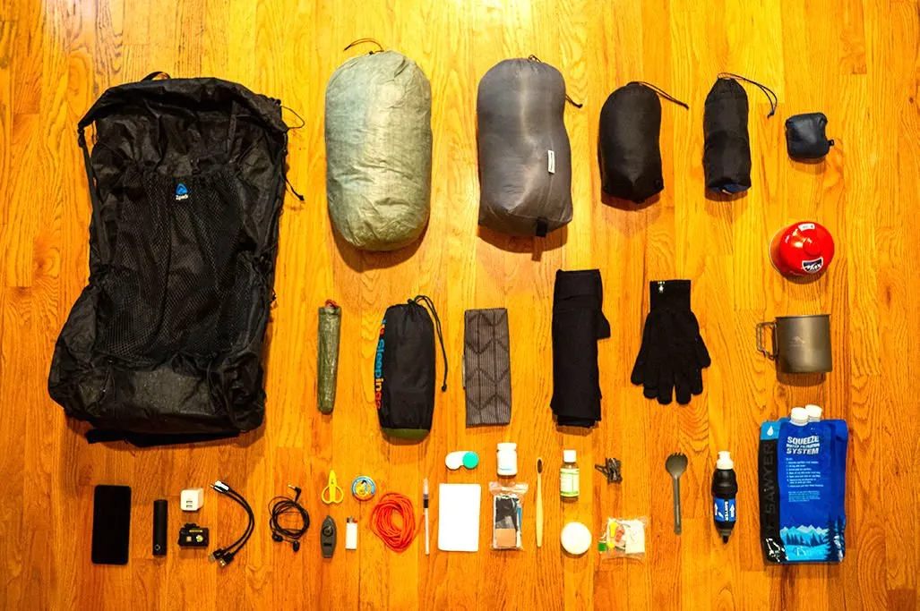 Essential backpacking safety gear including first aid kit, navigation tools and emergency equipment