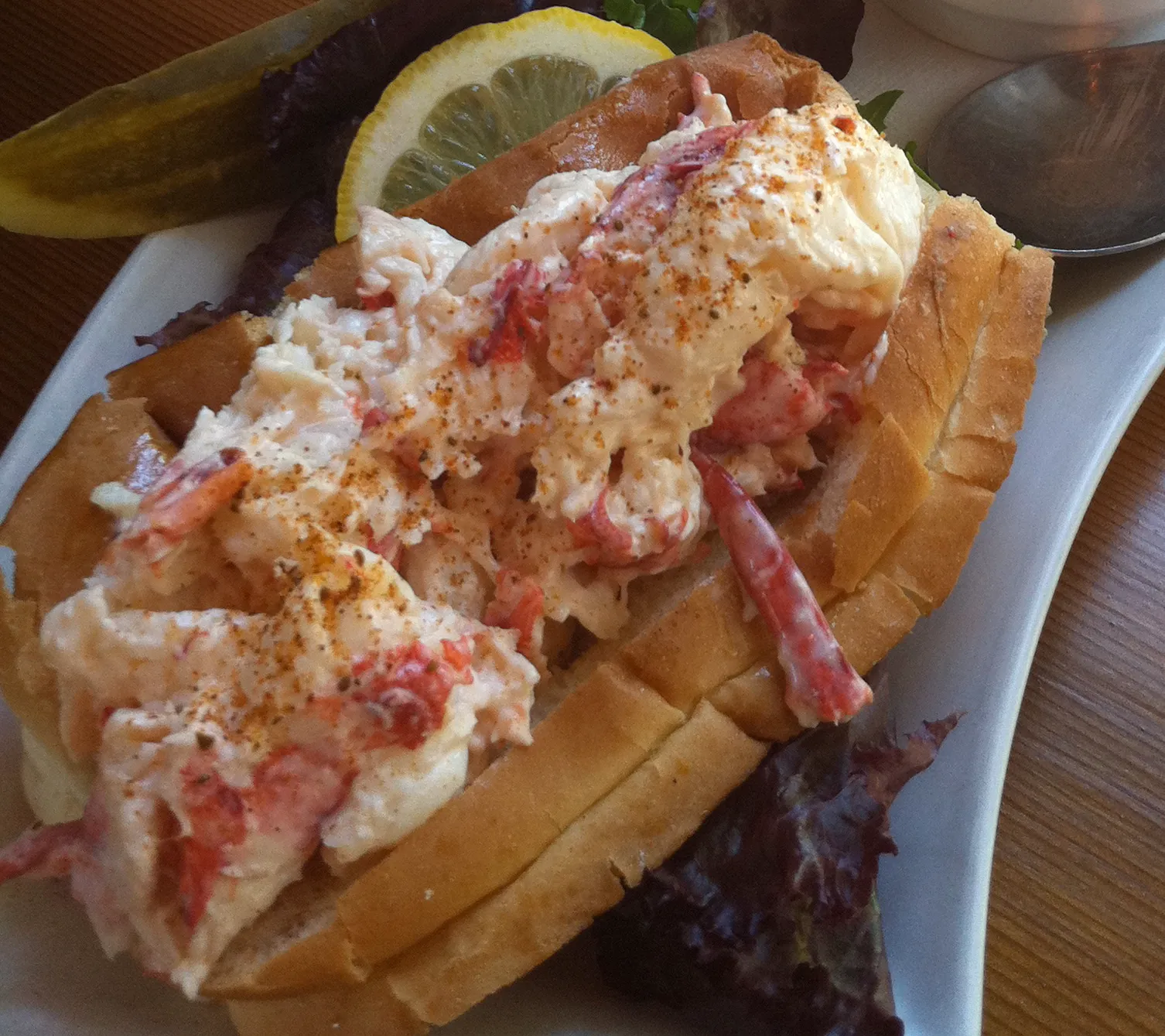 Fresh Maine lobster roll served on a traditional New England-style bun with crispy fries