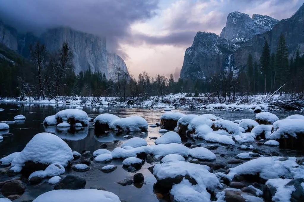 Winter landscape at Yosemite Valley View with snow-covered rocks in Merced River