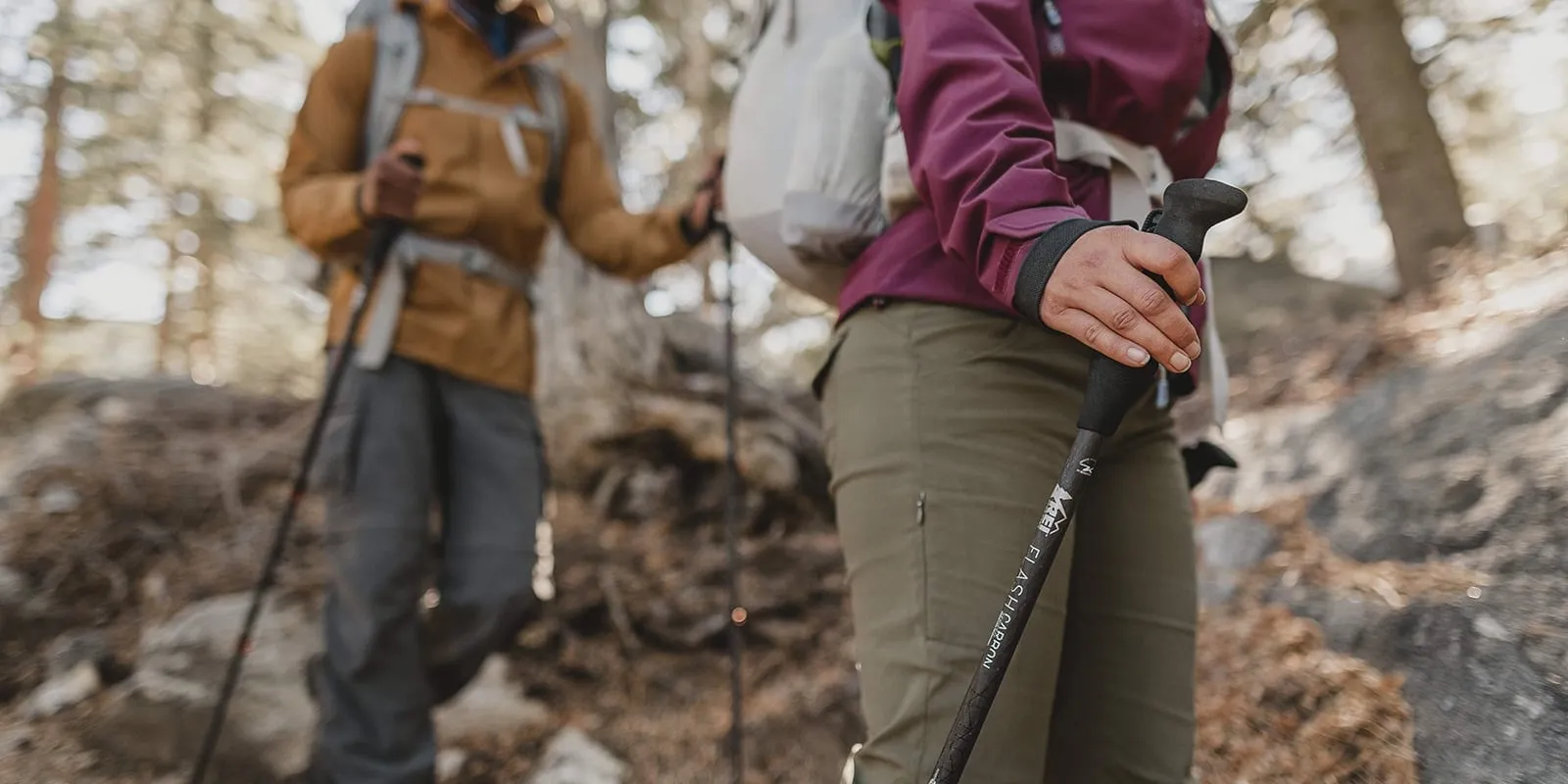 Hiker using aluminum poles on rocky mountain terrain demonstrating their durability