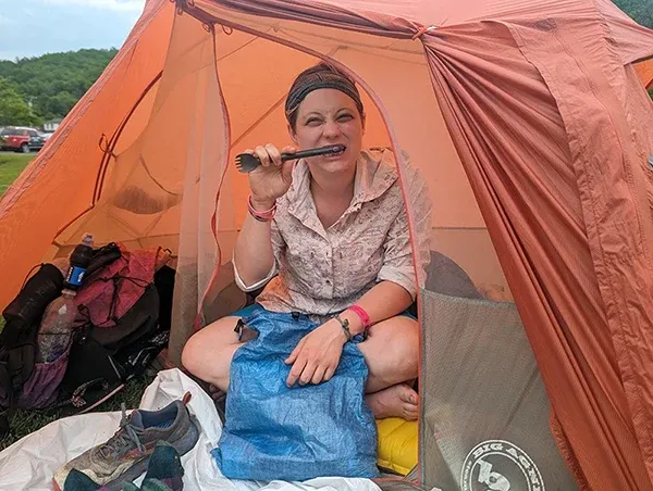 Woman camping in tent highlighting PFAS exposure concerns in outdoor gear