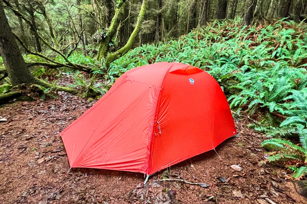 Four person backpacking tent in mountain setting demonstrating weather resistance and seasonal versatility