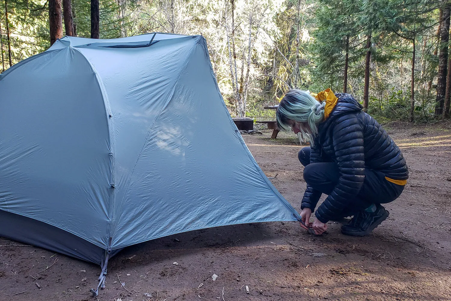Hiker demonstrating Sea to Summit Telos TR2 tent rainfly setup process
