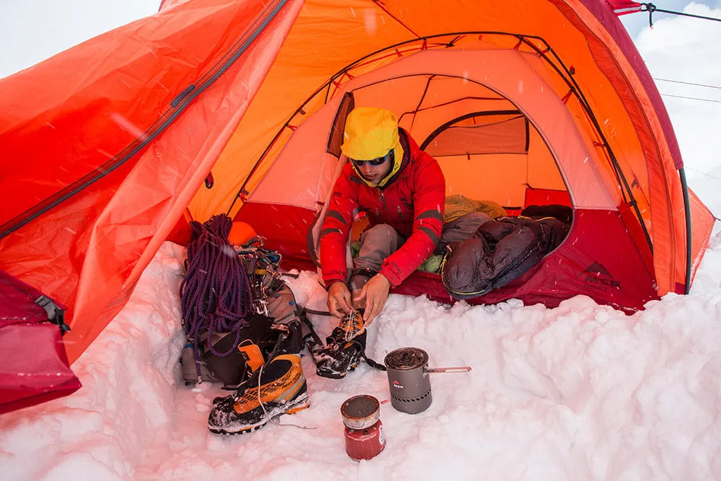 Camper using 3-season tent in ideal spring weather with light breeze and partly cloudy sky