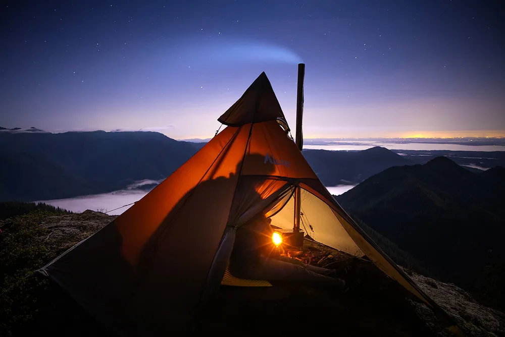 Hot tent camping setup with wood stove in winter conditions