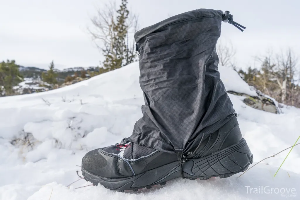Hiker wearing waterproof gaiters while snowshoeing in winter mountains