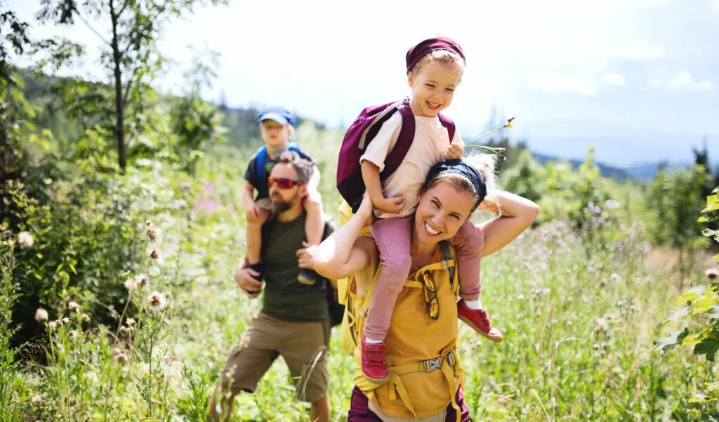 Family with children hiking on an easy nature trail through forest